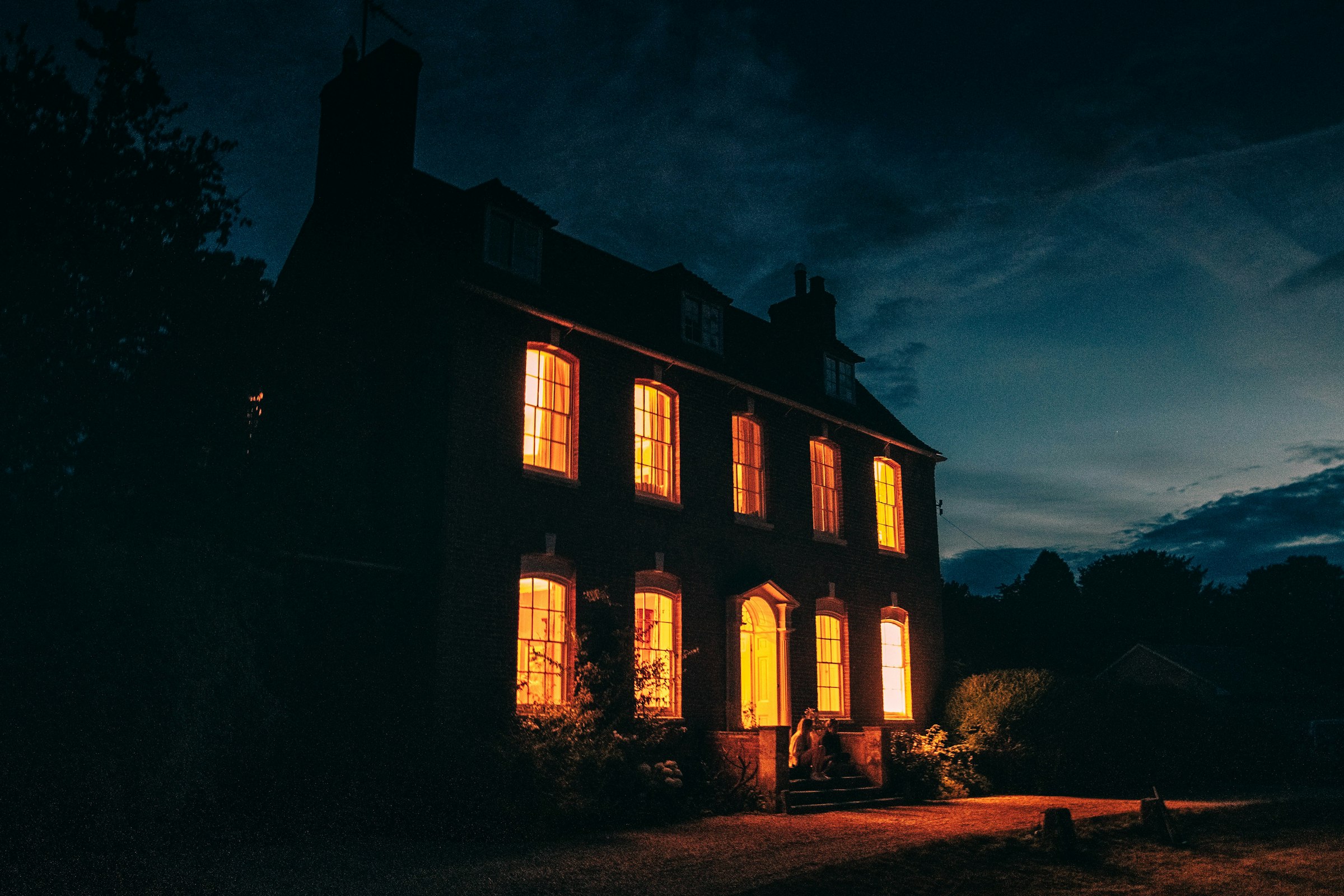 A brick house at night with every window lit